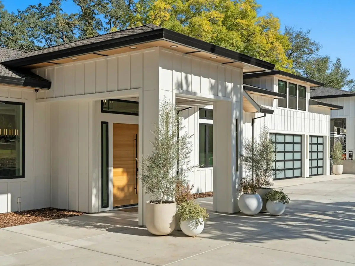 Wide concrete driveway in front of a modern white house